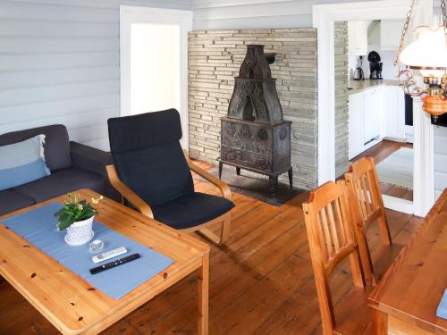 uma sala de estar com uma mesa, uma cadeira e um fogão em Holiday Home Johans Maria stova - FJS606 by Interhome em Arnefjord