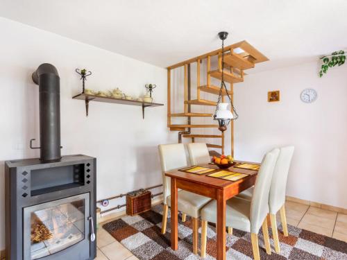 a dining room with a table and a wood stove at Holiday Home Lhotka nad Bečvou by Interhome in Lhotka nad Bečvou