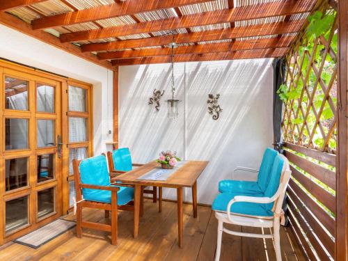 a dining room with a wooden table and blue chairs at Holiday Home Lhotka nad Bečvou by Interhome in Lhotka nad Bečvou