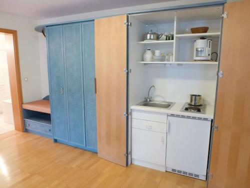 una pequeña cocina con armarios azules y fregadero en Apartment Flesch-1 by Interhome, en Schelingen