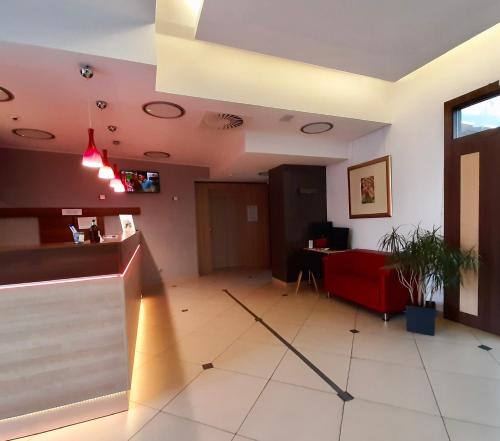 a waiting room with a red couch and a table at Poleczki Residence Apartments in Warsaw