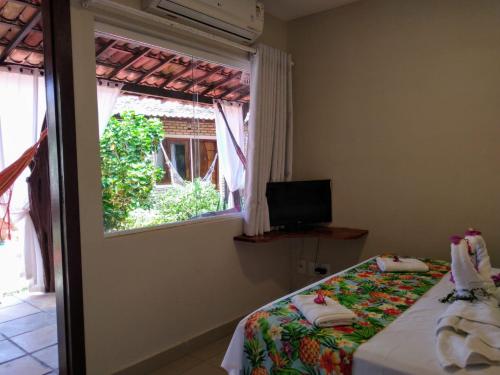 um quarto com uma cama e uma janela em Pousada Mar Mai em Pipa