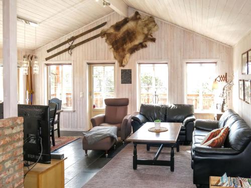 ein Wohnzimmer mit Sofas und einem Tisch in der Unterkunft Chalet Eikebu - SOW137 by Interhome in Fossdal