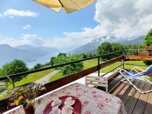 balcón con mesa y sillas y vistas a las montañas en Apartment Cà Mia by Interhome, en Dosso del Liro