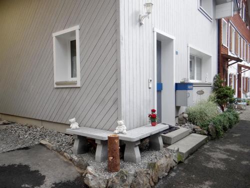 un banc à l'extérieur d'un bâtiment avec deux chats. dans l'établissement Apartment Bühl 13 by Interhome, à Engelberg