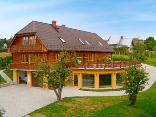 una gran casa de madera con techo de gambrel en Holiday Home Borówna by Interhome, en Lipnica Górna