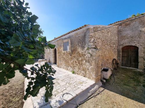 an old stone building with a door and a yard at Il Casale Suite&Rooms in Burgio