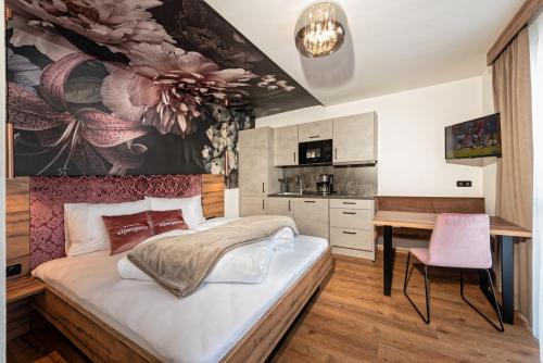a bedroom with a large bed and a desk at Alpenperle Apartments in Ladis