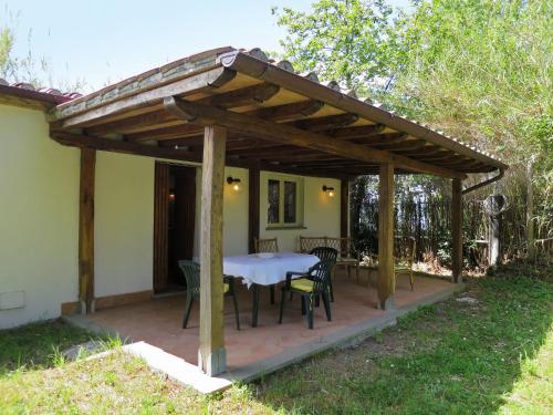 a wooden pergola with a table and chairs on a patio at Holiday Home Chalet del Lago by Interhome in Bolsena