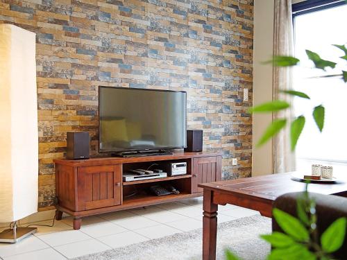 a living room with a television on a wooden entertainment center at Apartment Witthuus-Baltrum by Interhome in Norddeich