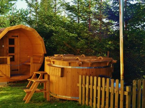 a wooden hot tub and a sauna next to a fence at Holiday Home Villa Amber Gąski-3 by Interhome in Gąski