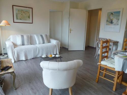 a living room with a white couch and chairs at Apartment Domaine de Clairefontaine-1 by Interhome in Deauville