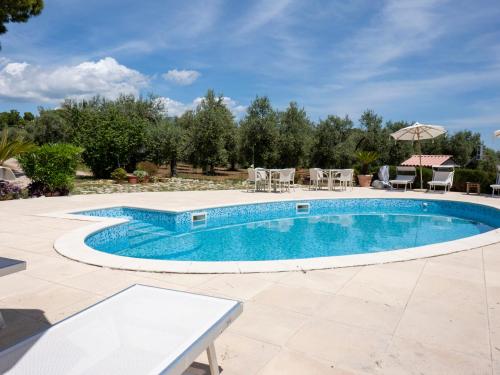a pool with a table and chairs in a yard at Apartment Saha by Interhome in Sperlonga
