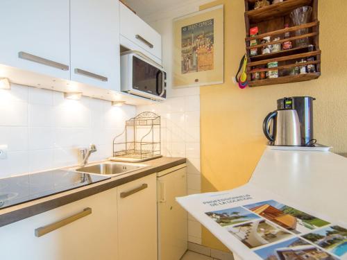a small kitchen with a sink and a microwave at Apartment Les Marines-29 by Interhome in La Foux