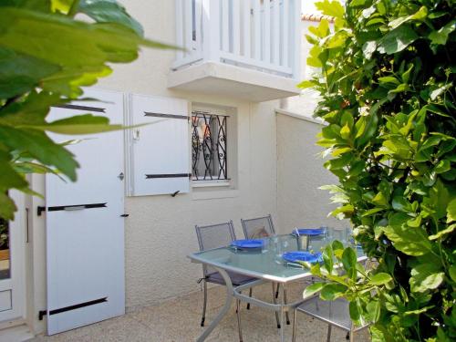 une table et des chaises dans un patio avec un bâtiment dans l'établissement Holiday Home Les Jardins de l'Océan-38 by Interhome, à Pontaillac