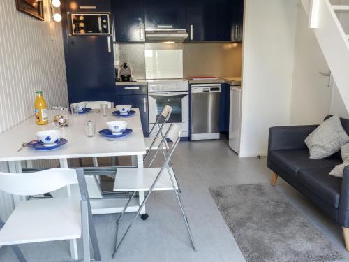 een keuken en een woonkamer met een tafel en stoelen bij Holiday Home Les Jardins de l'Océan-38 by Interhome in Pontaillac