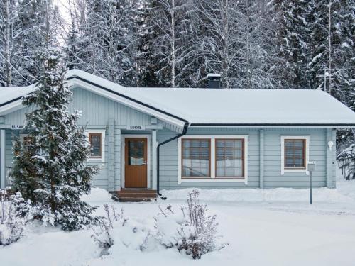a small blue house in the snow at Holiday Home Kurre by Interhome in Lahdenperä
