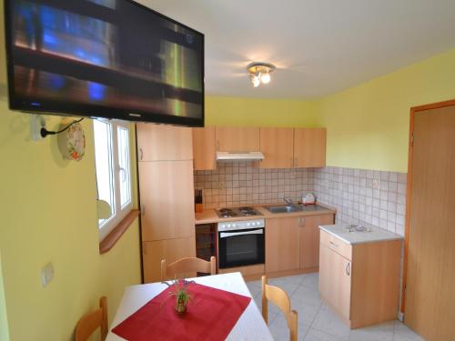 uma cozinha com uma mesa e uma televisão na parede em Apartment Lidija by Interhome em Vir