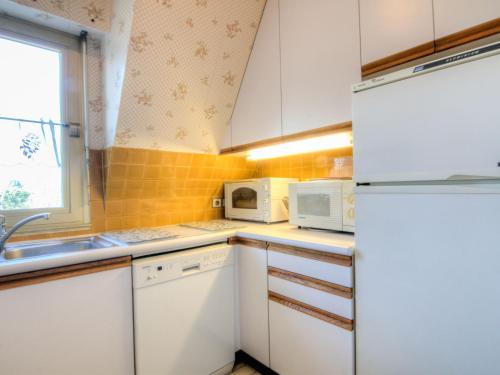 une cuisine avec des armoires blanches et un réfrigérateur blanc dans l'établissement Apartment Marie Antoinette-2 by Interhome, à Deauville