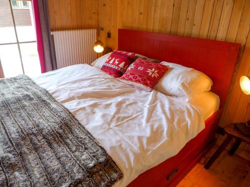 a bed with red and white sheets and pillows at Apartment Fury by Interhome in Verbier
