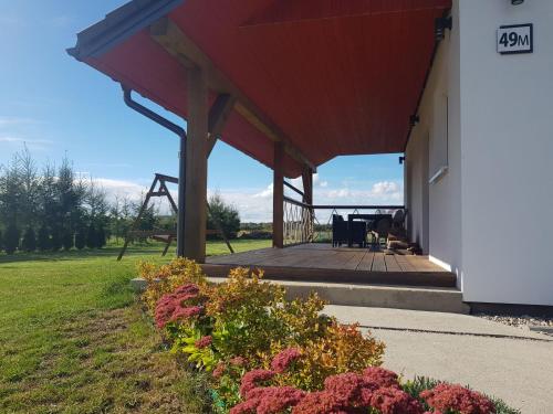 a pavilion with a picnic table on the side of a house at Holiday Home Modrzewiowy Zakątek by Interhome in Smołdziński Las