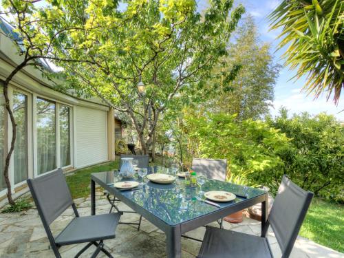 een patio met een glazen tafel en stoelen bij Holiday Home Agora by Interhome in Nice