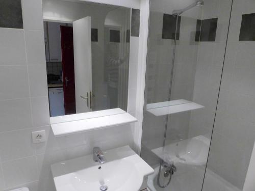 une salle de bain blanche avec un lavabo et une douche dans l'établissement Studio Les Moutières B1 et B2 - Val Claret-23 by Interhome, à Tignes
