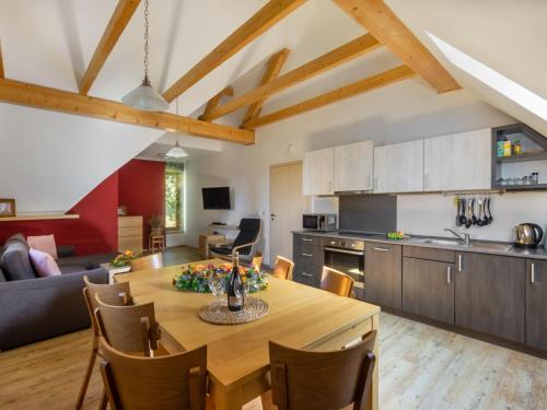 cocina y sala de estar con mesa de madera y sillas en Apartment Na mechu-2 by Interhome, en Mezná