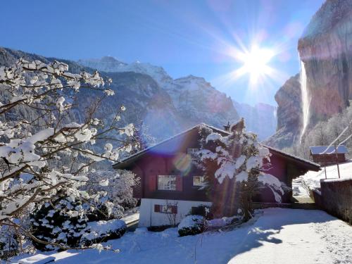 a house in the mountains with snow on the ground at Chalet Chalet am Schärm by Interhome in Lauterbrunnen