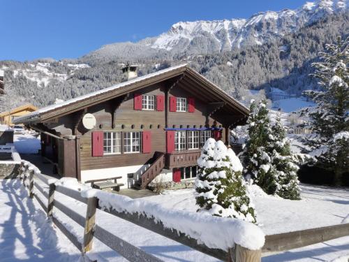a log cabin in the snow with a fence at Chalet Chalet am Schärm by Interhome in Lauterbrunnen