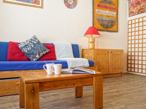 uma sala de estar com um sofá azul e uma mesa de centro em Studio Les Tommeuses - Val Claret-28 by Interhome em Tignes