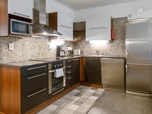 a kitchen with stainless steel appliances and brown cabinets at Holiday Home Vuokatinlampi 7 a - 2 ski passes incl- in by Interhome in Lahdenperä