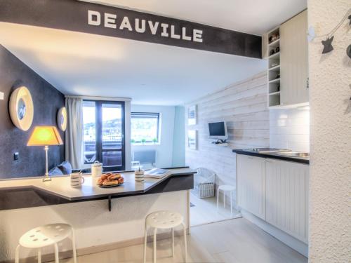 a kitchen with a dining table and stools at Studio Les Marinas-10 by Interhome in Deauville
