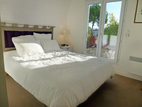 een groot wit bed in een slaapkamer met een raam bij Apartment Elisa-2 by Interhome in Trouville-sur-Mer