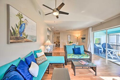 a living room with a blue couch and a ceiling fan at Sunny Marco Island Gem with Shared Pool and Dock! in Marco Island