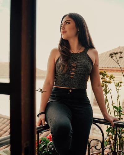 a woman is sitting on a railing at Wild Incas Hostel in Cuenca