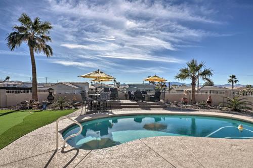 a pool with chairs and umbrellas on a patio at Pool and Lake Havasu Views Gorgeous Desert Escape! in Lake Havasu City