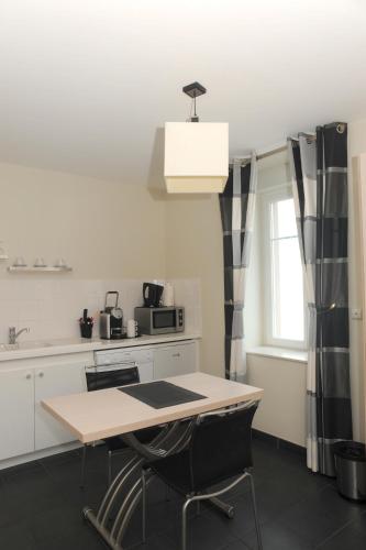 a kitchen with a table and two chairs and a window at Aux Jardins de L'Isle in Vienne