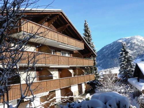 a building in the snow with a mountain at Apartment Kristall by Interhome in Zweisimmen