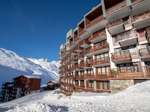 un bâtiment dans la neige avec une montagne en arrière-plan dans l'établissement Apartment Le Curling B - Val Claret-38 by Interhome, à Tignes