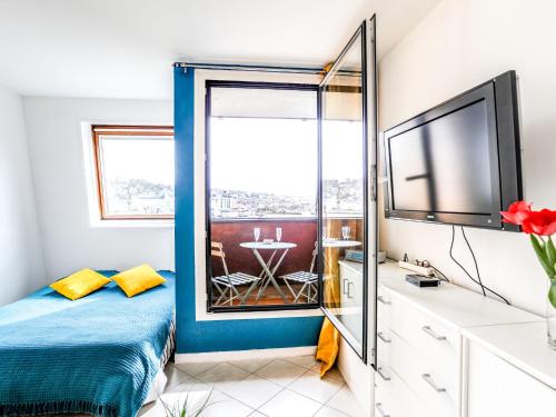 um quarto com uma cama, uma televisão e uma janela em Studio Les Marinas-8 by Interhome em Deauville