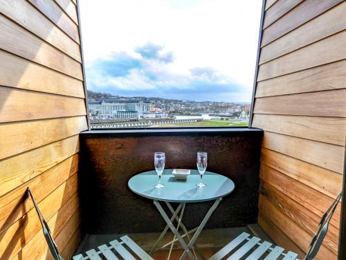einen kleinen Tisch mit zwei Weingläsern auf dem Balkon in der Unterkunft Studio Les Marinas-8 by Interhome in Deauville