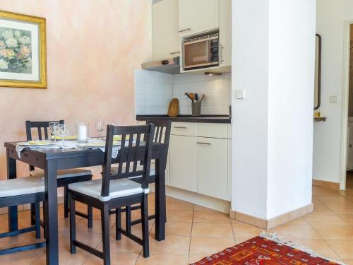 kuchnia i jadalnia ze stołem i krzesłami w obiekcie Apartment Village Marin-16 by Interhome w mieście La Foux