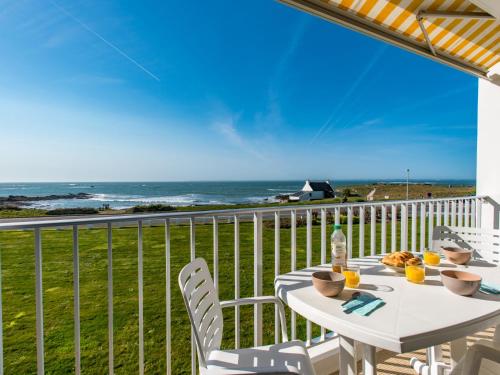 einen weißen Tisch und Stühle auf einem Balkon mit Meerblick in der Unterkunft Studio Les Trois Iles-2 by Interhome in Port-Haliguen