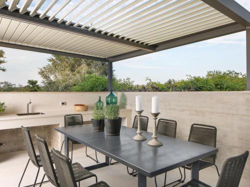 einen Tisch und Stühle auf einer Terrasse mit einer Pergola in der Unterkunft Holiday Home Oliva 2 by Interhome in Pelegrin