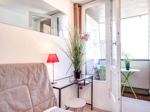 un salon avec une chaise et une table avec une lampe dans l'établissement Studio Les Marinas-9 by Interhome, à Deauville