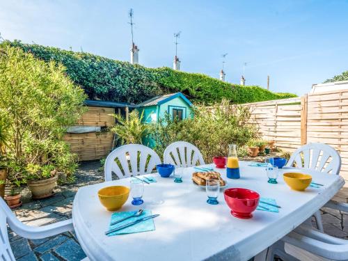 una mesa blanca con tazones y platos de comida. en Holiday Home Les Dunes-2 by Interhome, en Quiberon