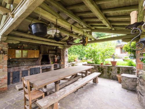 una cocina al aire libre con mesa de madera y banco en Villa Vista da Rocca di Papa-1 by Interhome, en Rocca di Papa