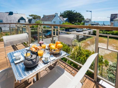 Una mesa en un balcón con naranjas y jugo. en Apartment Les Néréïdes by Interhome, en Quiberon