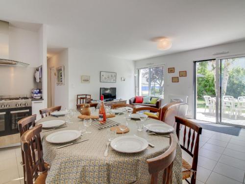 a dining room with a table and chairs and a kitchen at Holiday Home Ker-Heol by Interhome in Port Blanc